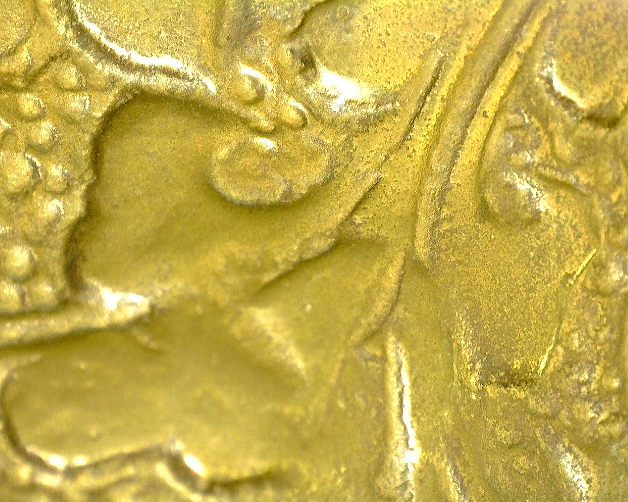 Detail van de handgegraveerde dhoti met scherpe florale ornamenten en natuurlijke patina.